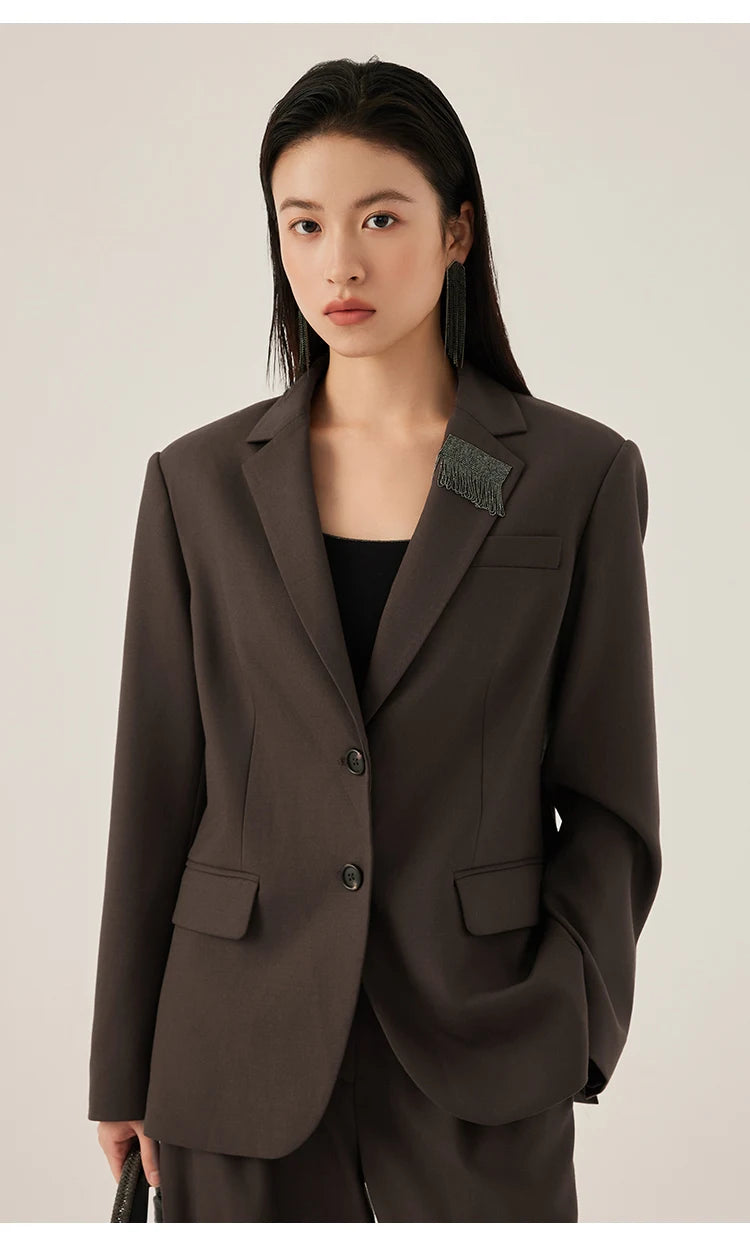 Woman in black chocolate blazer with rhinestone fringe detail, hand in pants pocket – from Borcelleclothes.
