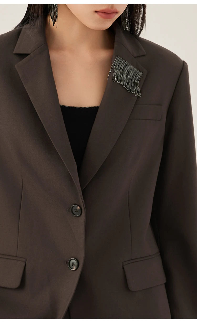 Woman wearing a black chocolate blazer with rhinestone fringe detail on lapel, upper part view – from Borcelleclothes.