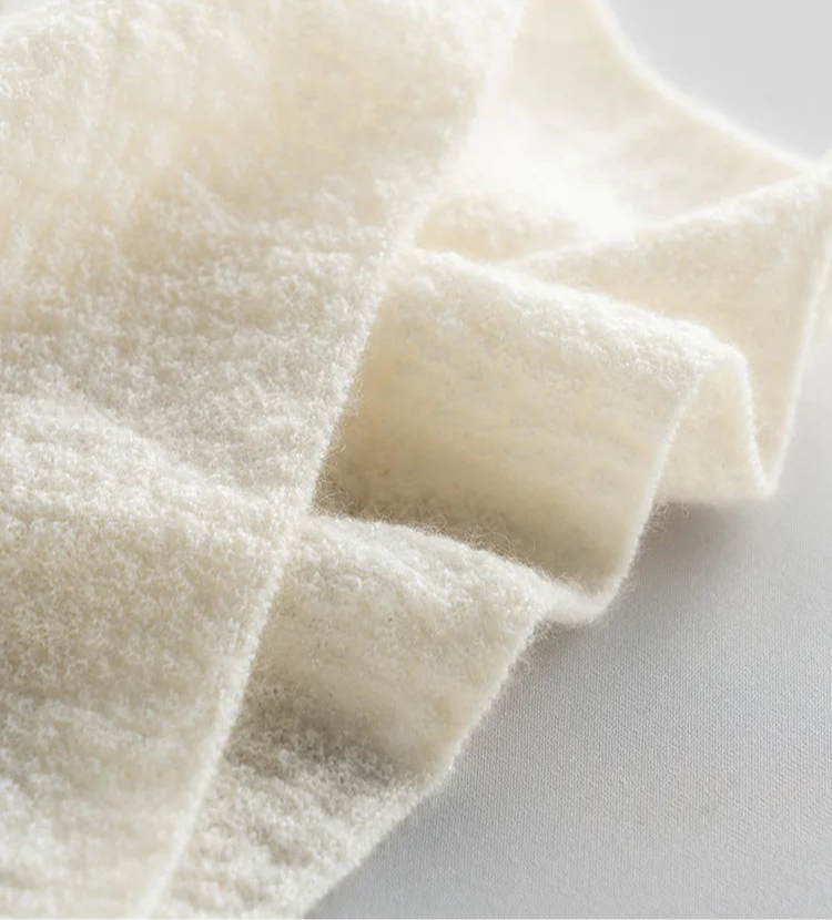 Detailed view of the bottom hem and surface texture of the bouclé cashmere top in Pearl Bush — From Borcelleclothes.