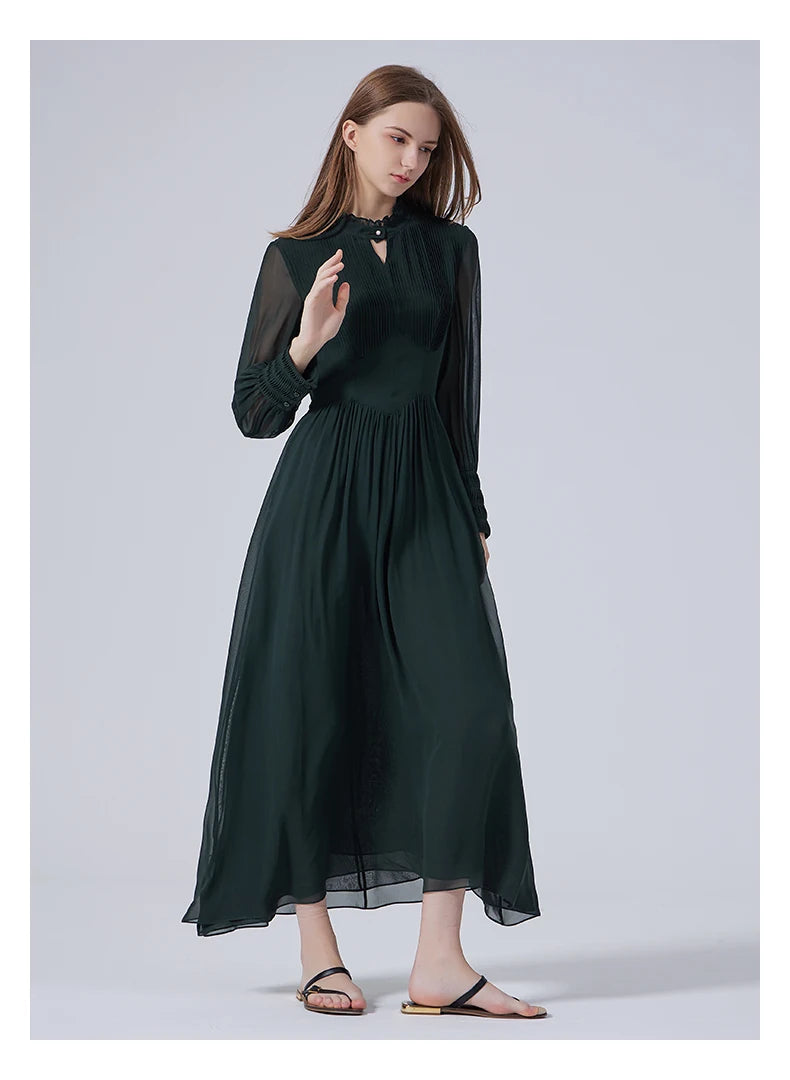 Model raising one arm in the Lunar Green dress, revealing the transparency of the sleeve and extended cuff. From Borcelleclothes.