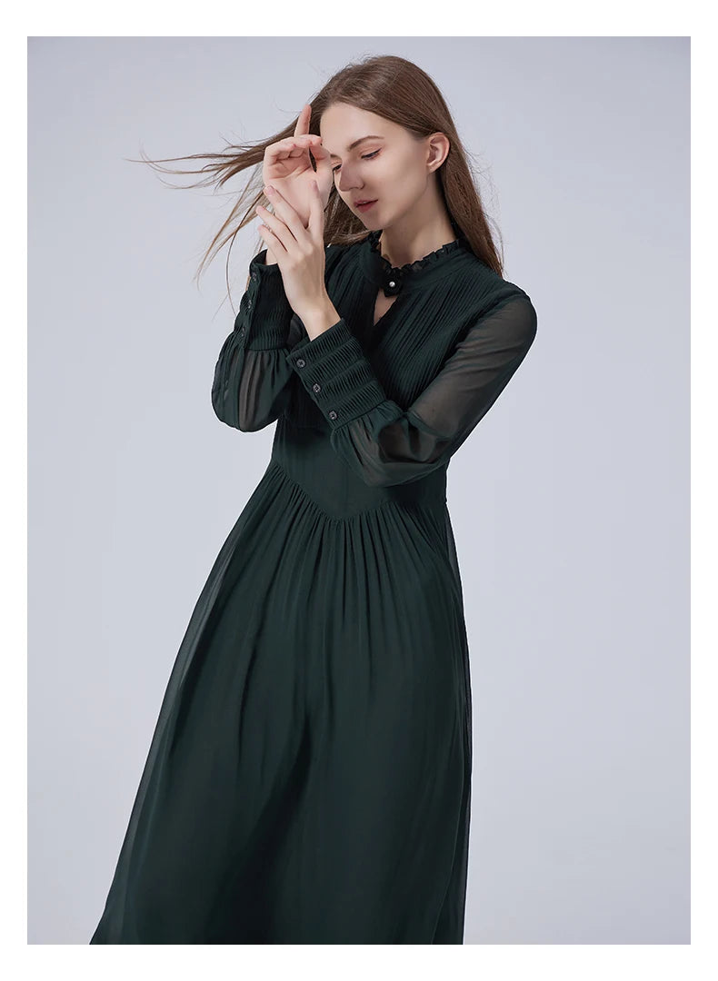 Model in the Lunar Green dress with hands raised, revealing the lightness of the sheer sleeves and flow of silk chiffon. From Borcelleclothes.