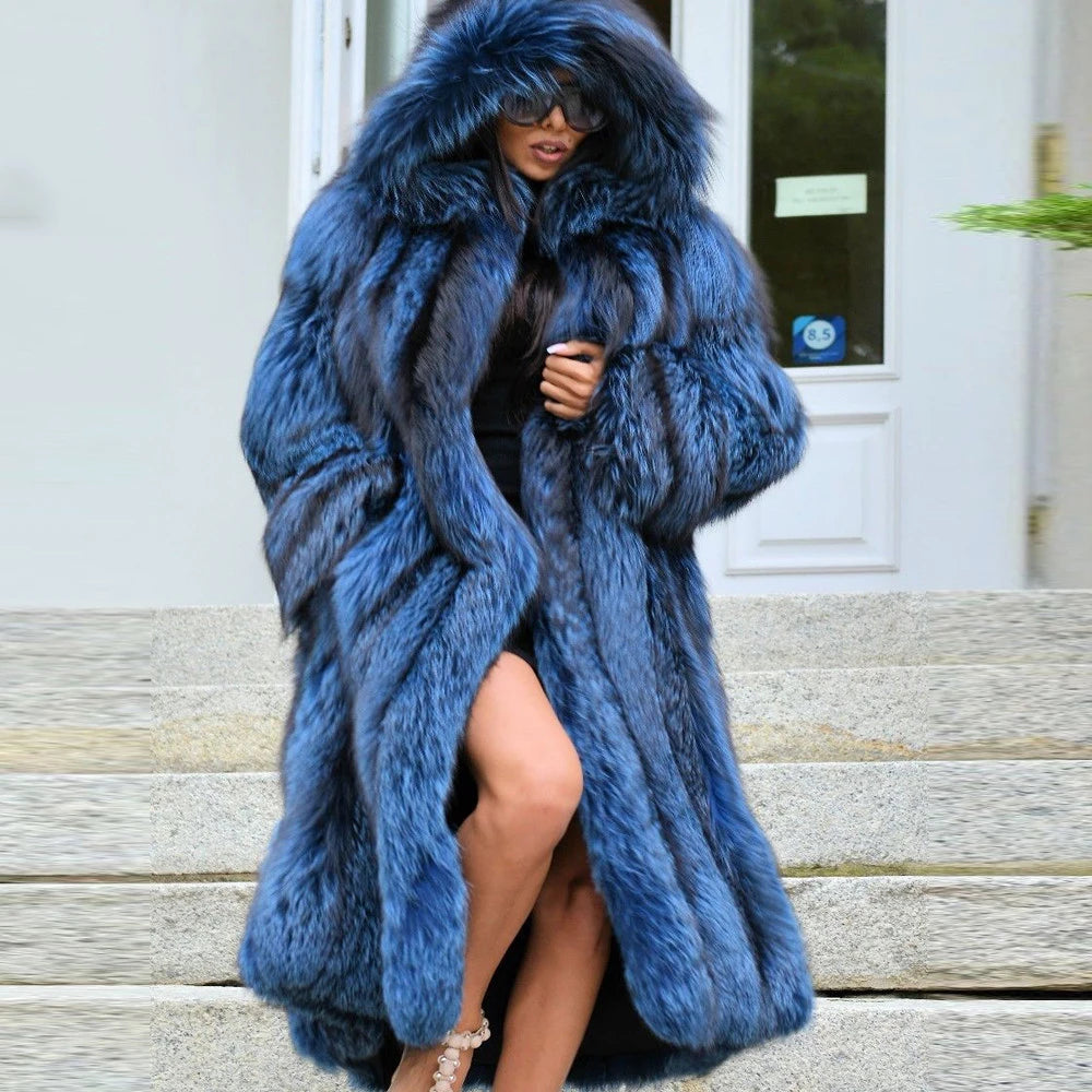 A woman in a sweeping Calypso silver fox fur coat descends a staircase, the coat’s flowing length mirroring her poised and effortless presence. From Borcelleclothes.