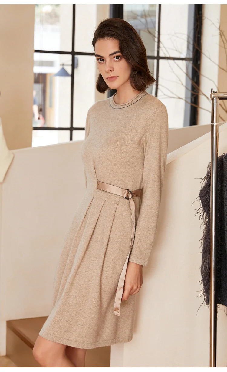 Woman in Dark Vanilla dress leaning against staircase with bent leg — From Borcelleclothes.