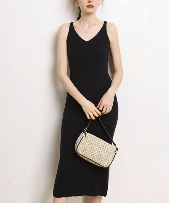 Model wearing a Women's Cashmere Midi Dress in Onyx, holds a bag. From Borcelleclothes.From Borcelleclothes.