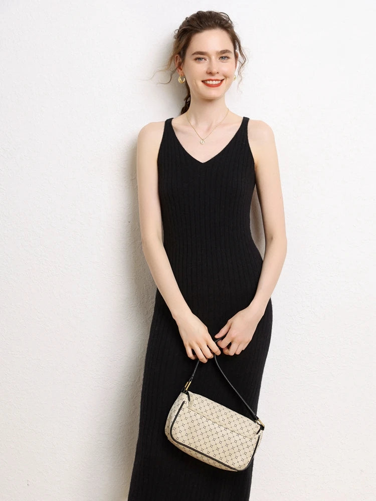 Model smiling in a Women's Cashmere Midi Dress in Onyx, featuring front and back V-necklines and a ribbed texture for a slimming silhouette. From Borcelleclothes.