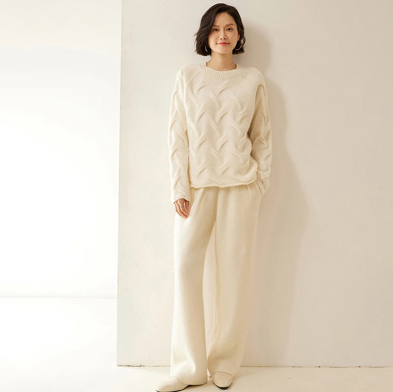 Model with bent leg and hand in pocket wearing Soft Amber pleated cashmere trousers — From Borcelleclothes.