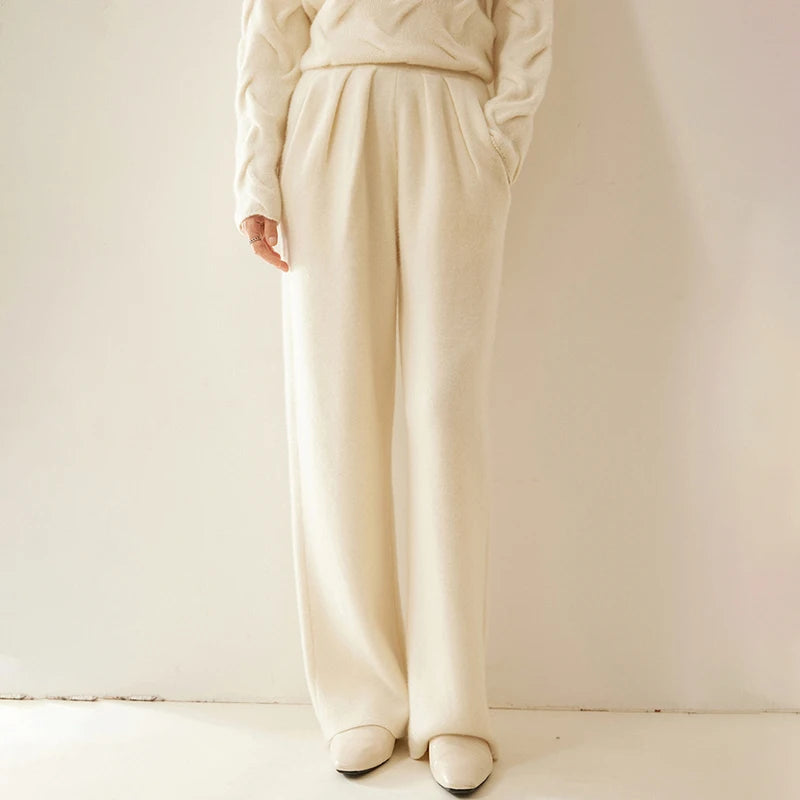 Model with hand in pocket wearing Soft Amber pleated cashmere trousers — From Borcelleclothes.
