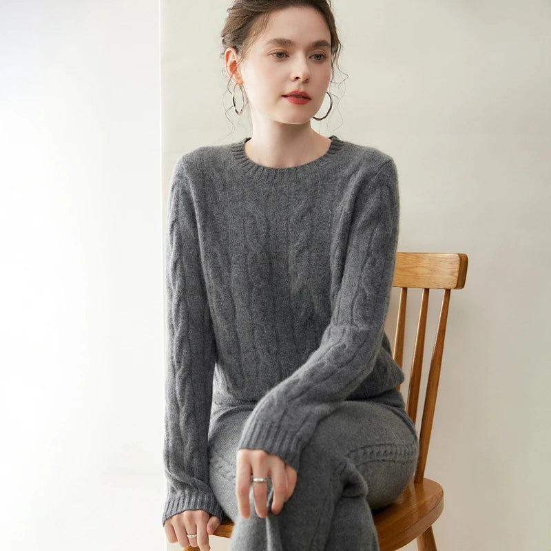 Women's cashmere set with two-strand cables in Davy Grey, model sitting on chair — From Borcelleclothes.