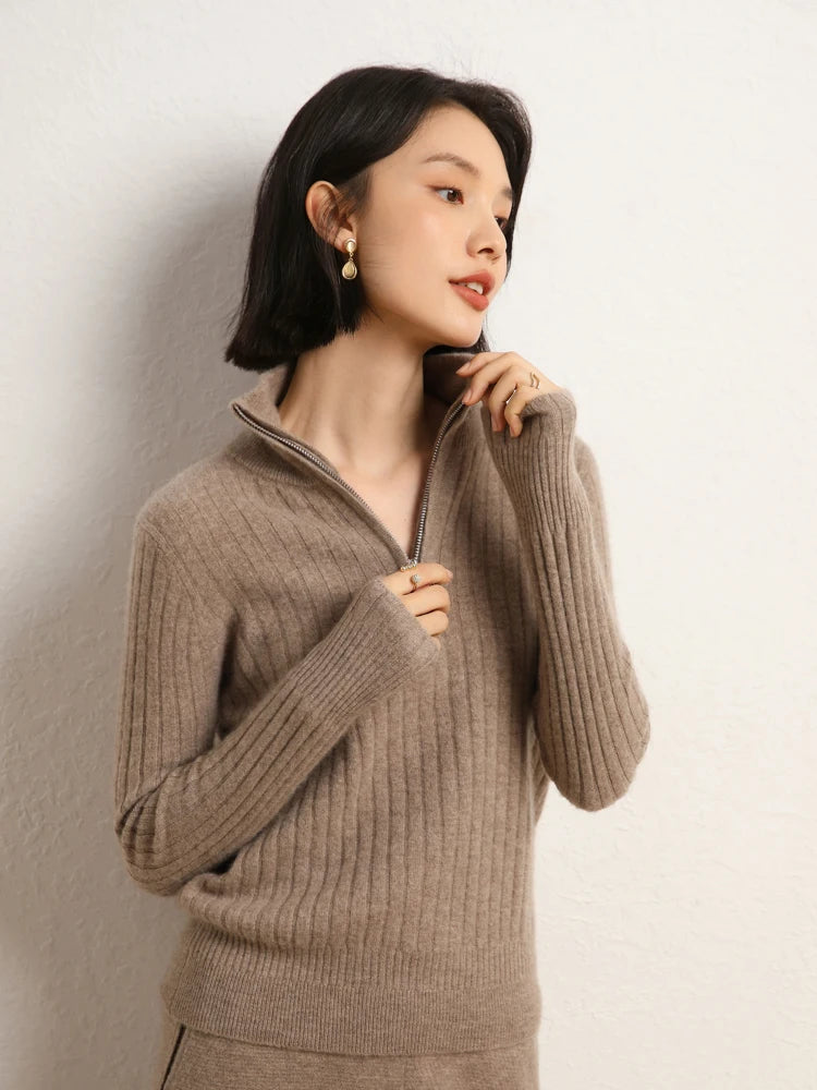 Model zipping up collar of cashmere sweater in shifting ribs, Pale Taupe — From Borcelleclothes.