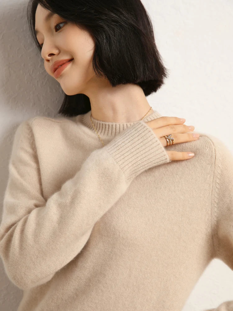 Woman in Almond cashmere sweater looking to the side with hand on opposite shoulder – From Borcelleclothes.