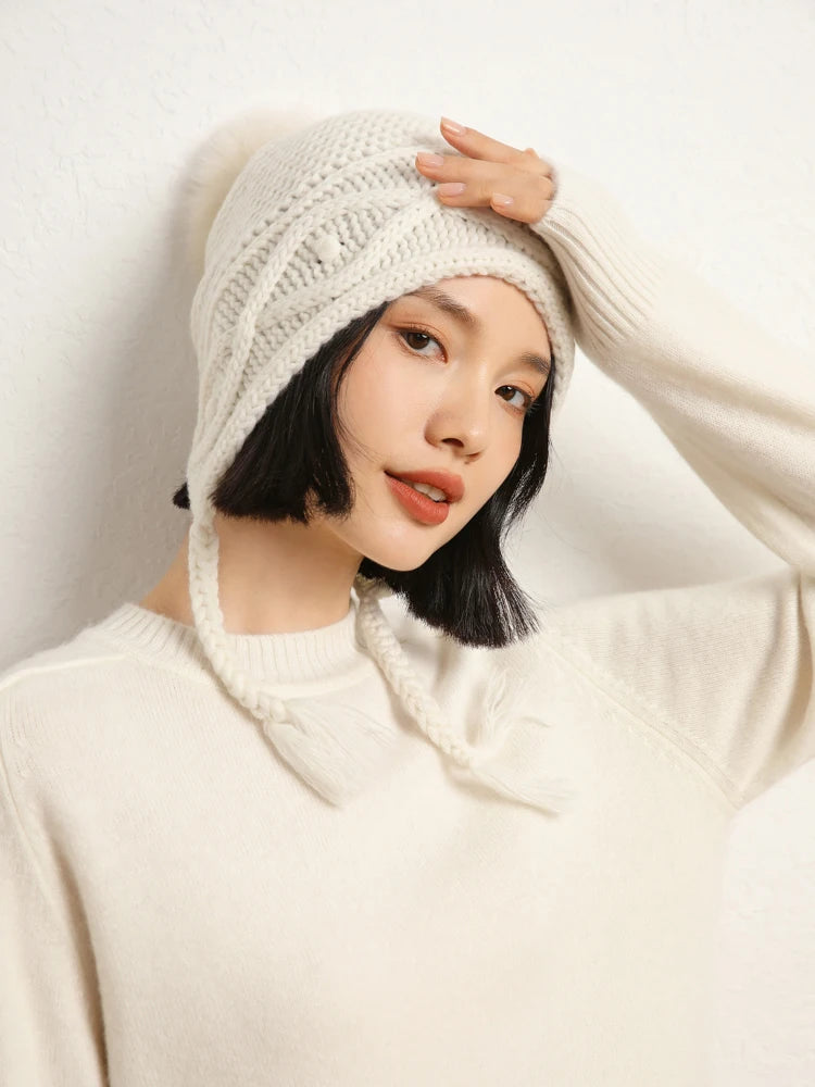 Woman in White Chocolate cashmere sweater touching white hat – From Borcelleclothes.