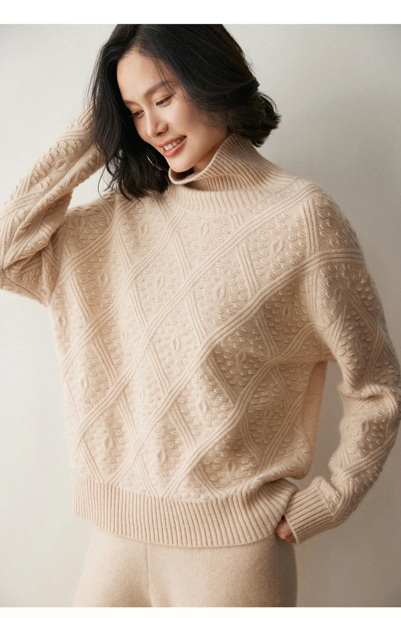Model in Almond cashmere sweater with embossed diamonds and bobble stitches, gently touching her hair — From Borcelleclothes.