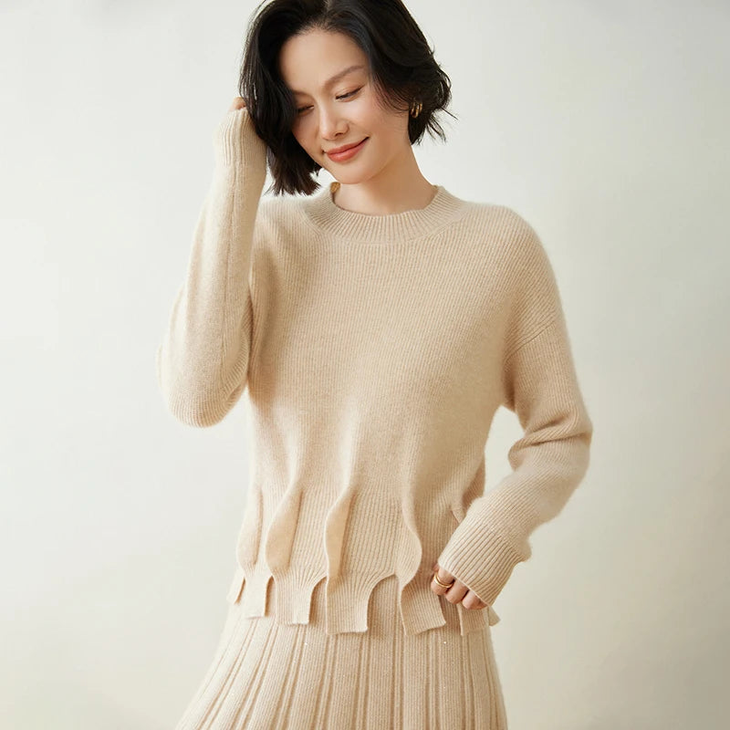 Model adjusting hair while wearing vanilla-colored cashmere sweater with sculpted waistline – From Borcelleclothes.