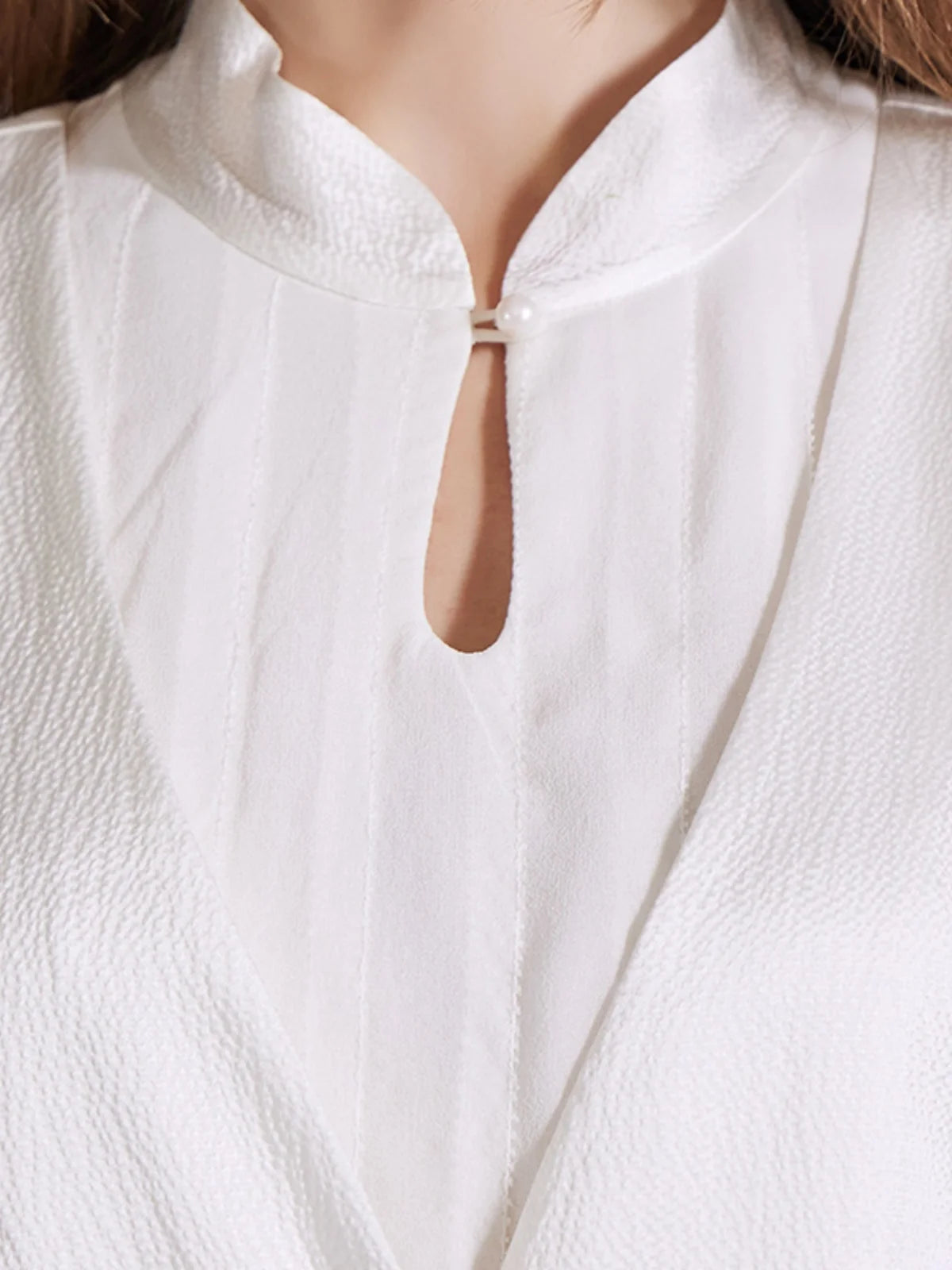 Close-up of the vest and the upper bodice of the chiffon silk dress with pleated details and mandarin collar. From Borcelleclothes.