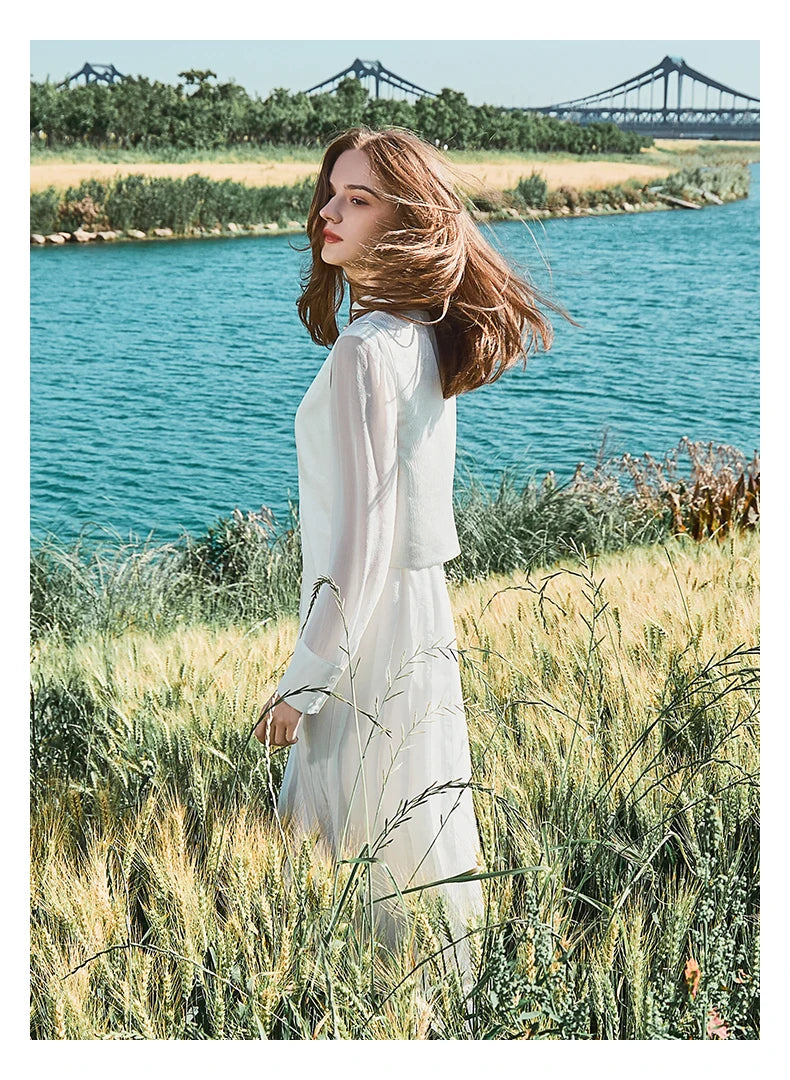 Model in full ensemble standing sideways in natural surroundings. From   Borcelleclothes.