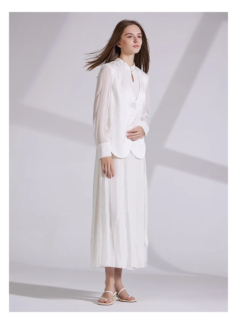 Model in full ensemble, gently touching the jacquard vest closure. From Borcelleclothes.