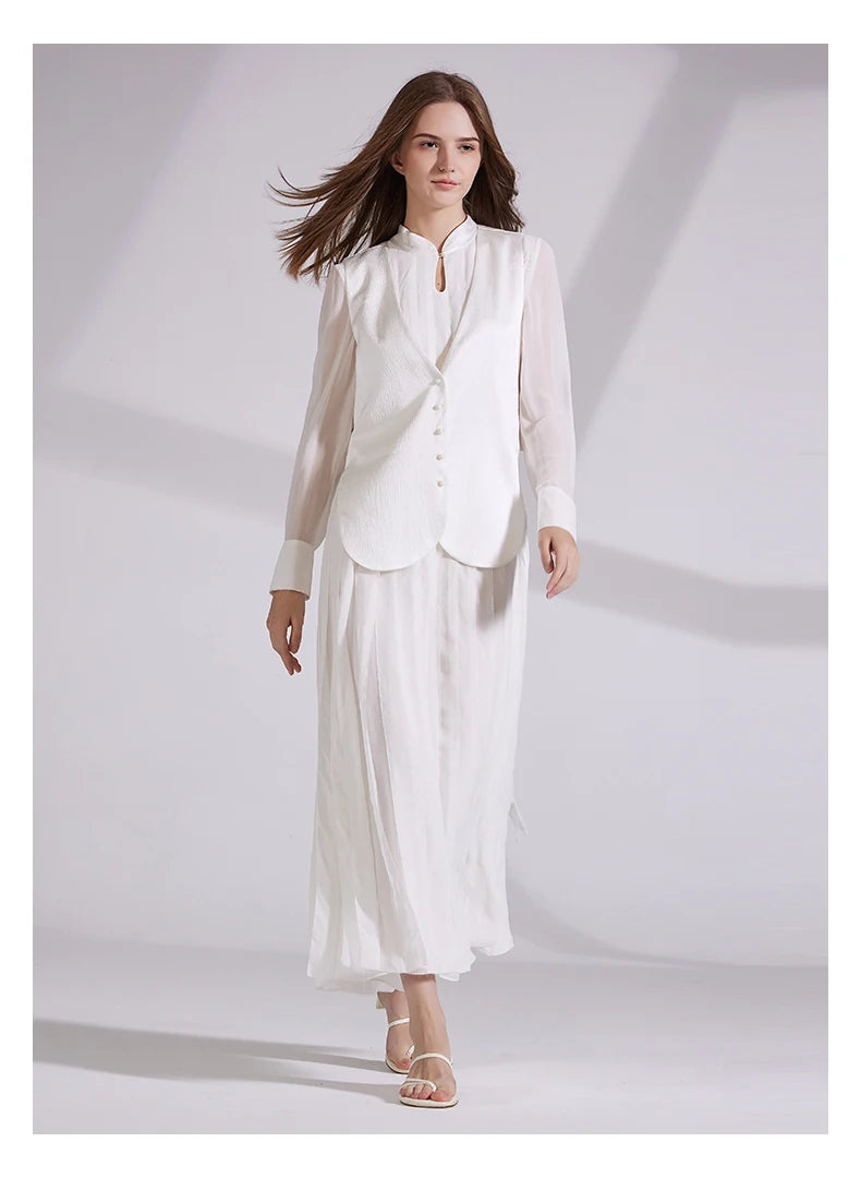 Chiffon and jacquard silk ensemble in Whisper color, featuring pleated bodice and skirt with pearl-buttoned vest. From Borcelleclothes.