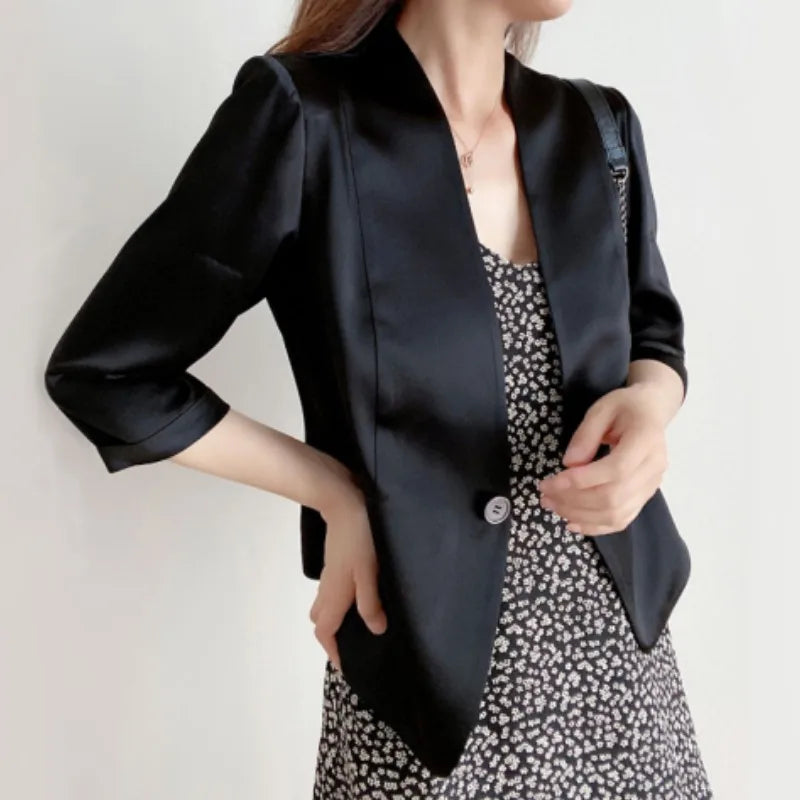 Woman in Onyx collarless silk jacket with hand on hip — a composed silhouette in a deep, grounded tone. From Borcelleclothes.