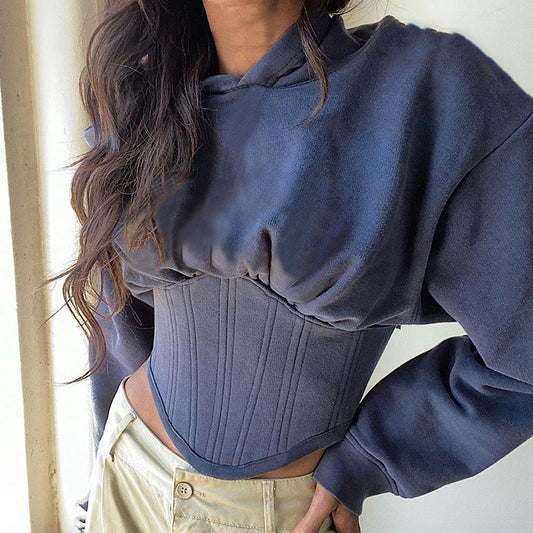 Model wearing the Women's Contemporary Hooded Corset in Comet color, showcasing the unique design that combines a classic hood and long sleeves with elastic cuffs, transitioning into a structured corset bottom with ribbed bias. Made from premium cotton, this piece offers a stylish and comfortable look for modern wardrobes. From Borcelleclothes.