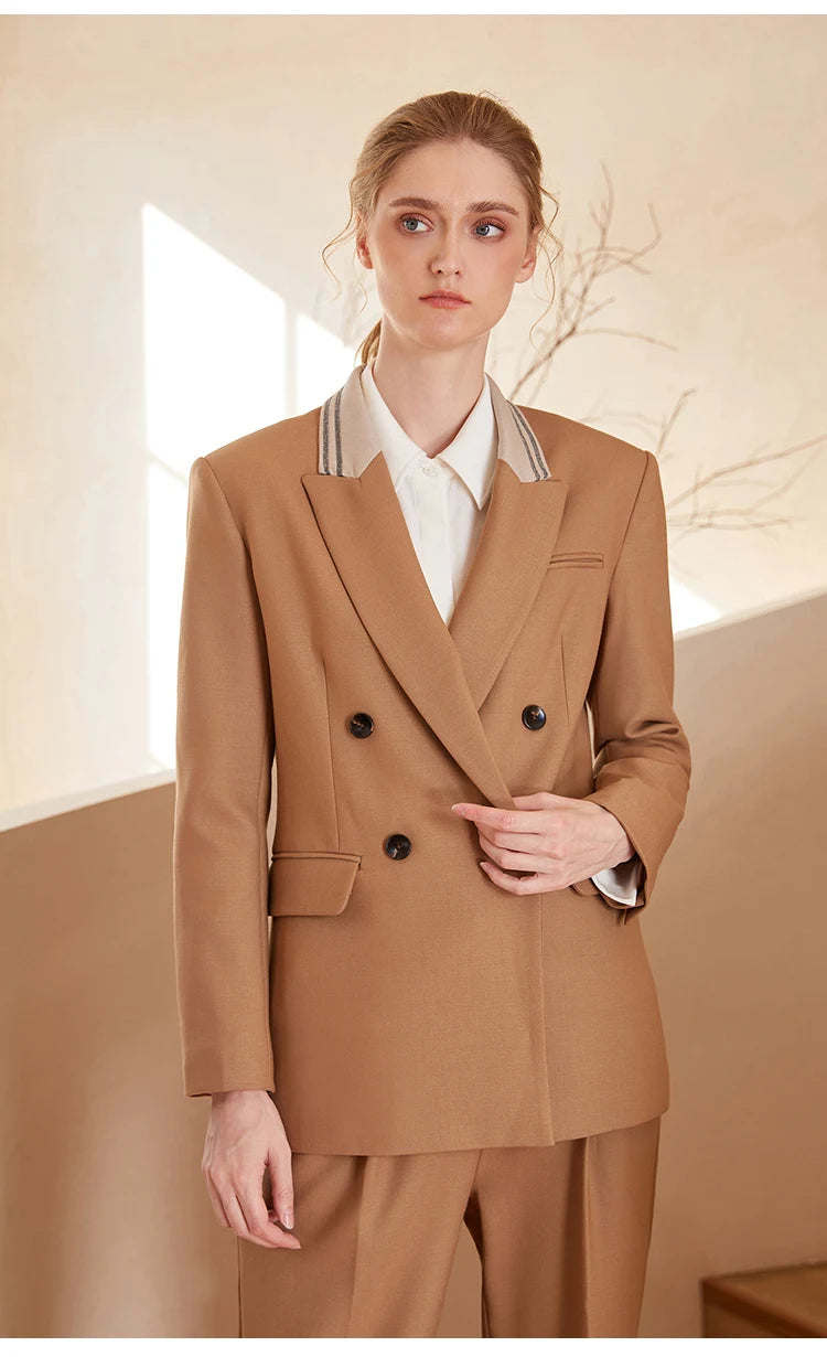 Woman in French Beige contrast-collar wool blazer, touching the front side of the blazer — From Borcelleclothes.