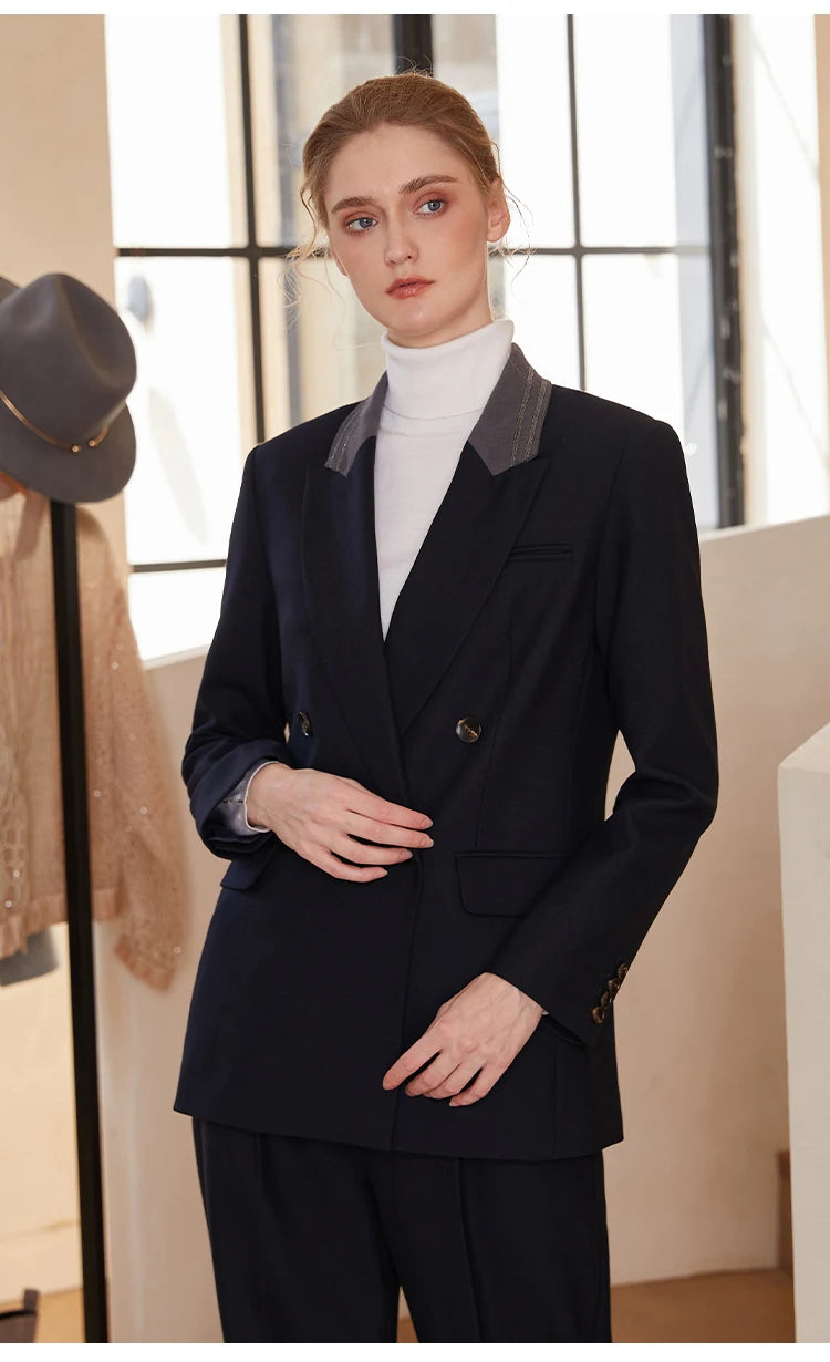 Woman in Mirage contrast-collar wool blazer, touching the front side of the blazer — From Borcelleclothes.