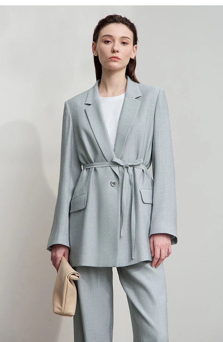 Woman holding beige bag while wearing Morning Blue crinkled viscose blazer – From Borcelleclothes.