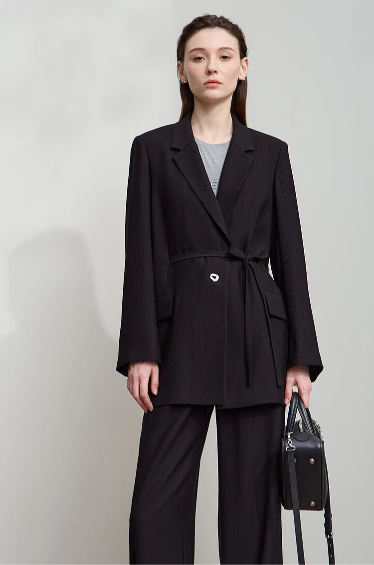 Woman holding black bag while wearing Onyx crinkled viscose blazer – From Borcelleclothes.