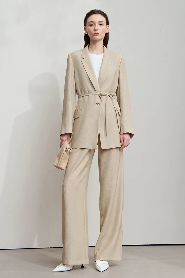 Woman holding bag while wearing Soft Amber crinkled viscose blazer – From Borcelleclothes.