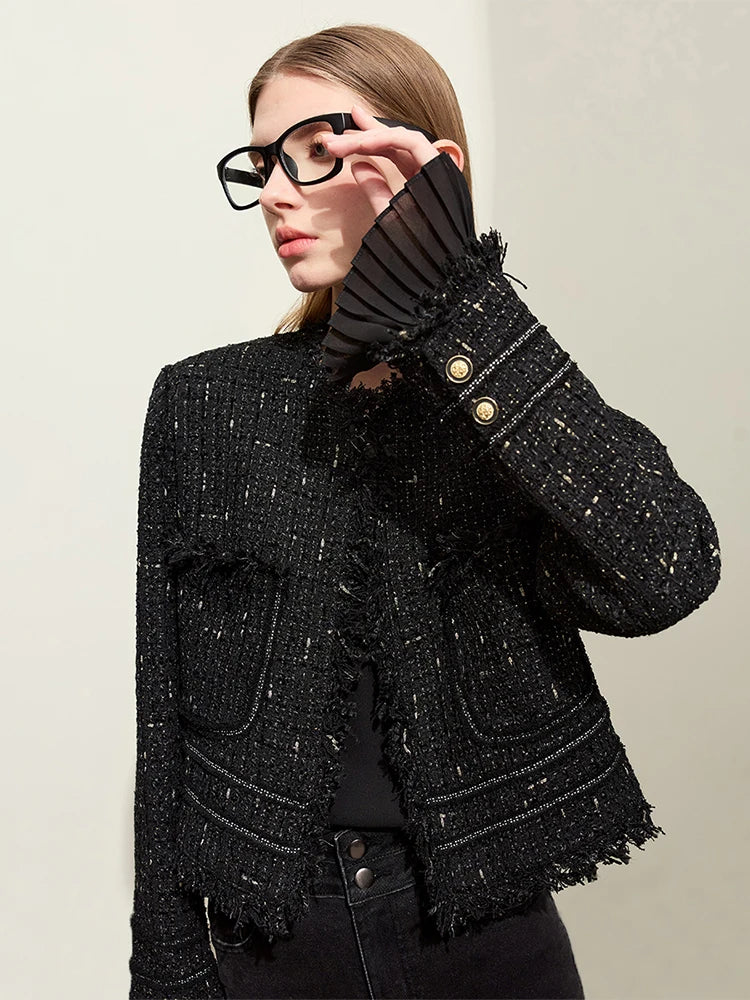 Model wearing Onyx cropped tweed jacket with sheer cuffs, adjusting glasses – From Borcelleclothes.