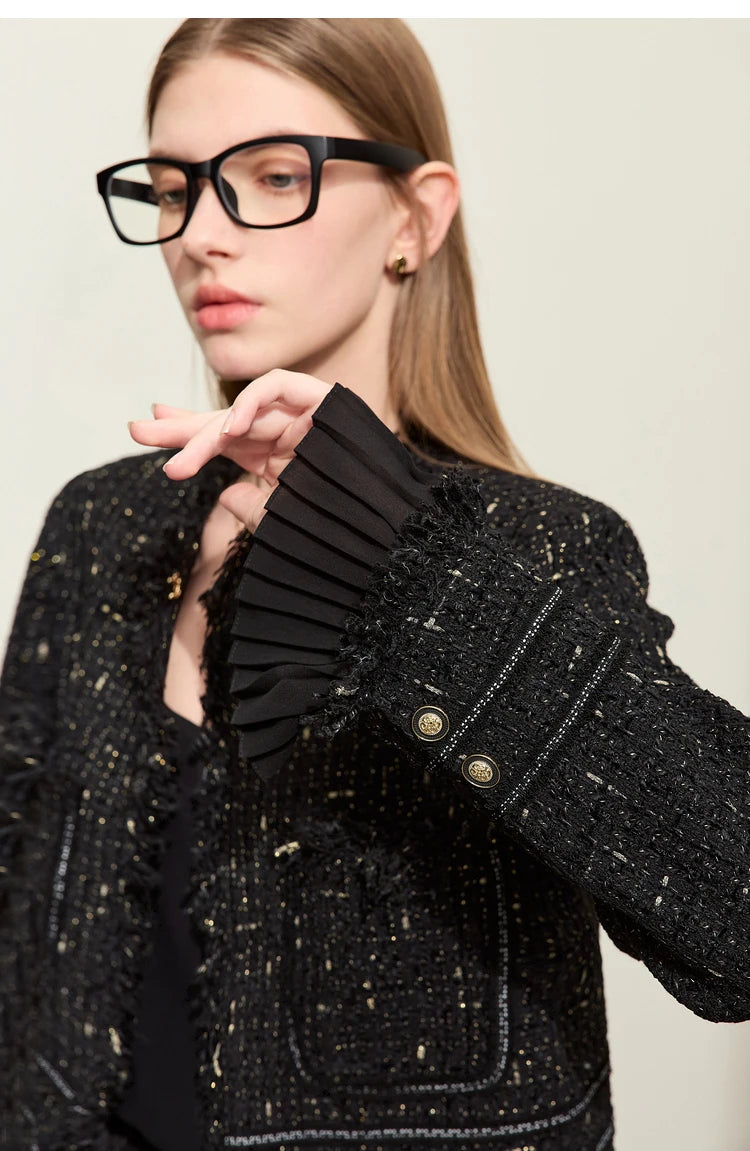 Model wearing Onyx cropped tweed jacket with sheer cuffs, bent arm pose – From Borcelleclothes.
