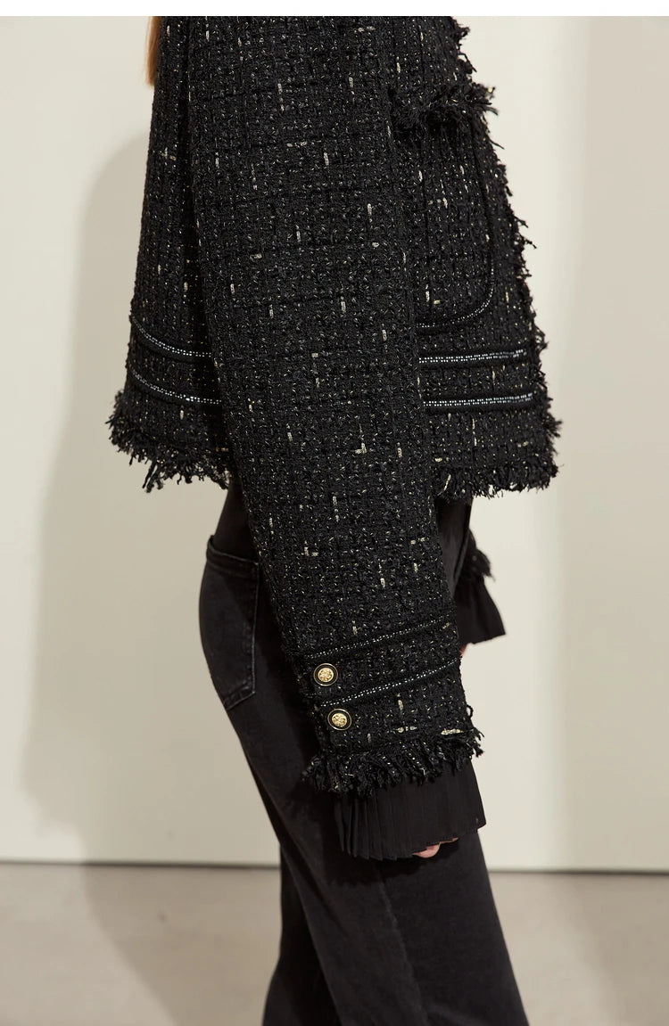 Model wearing Onyx cropped tweed jacket with sheer cuffs, side view – From Borcelleclothes.