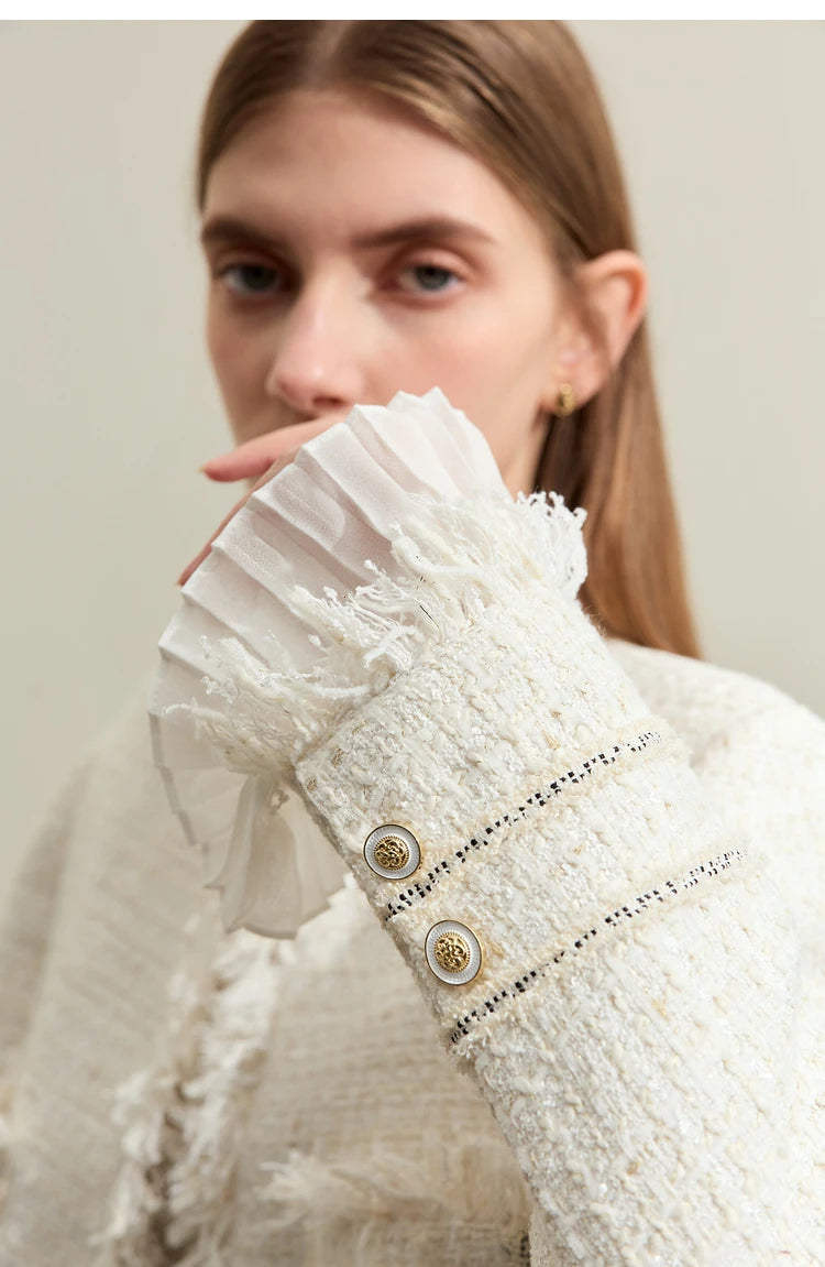 Woman in Platinum cropped tweed jacket with sheer cuffs, bent arm showing pleated cuff – From Borcelleclothes.