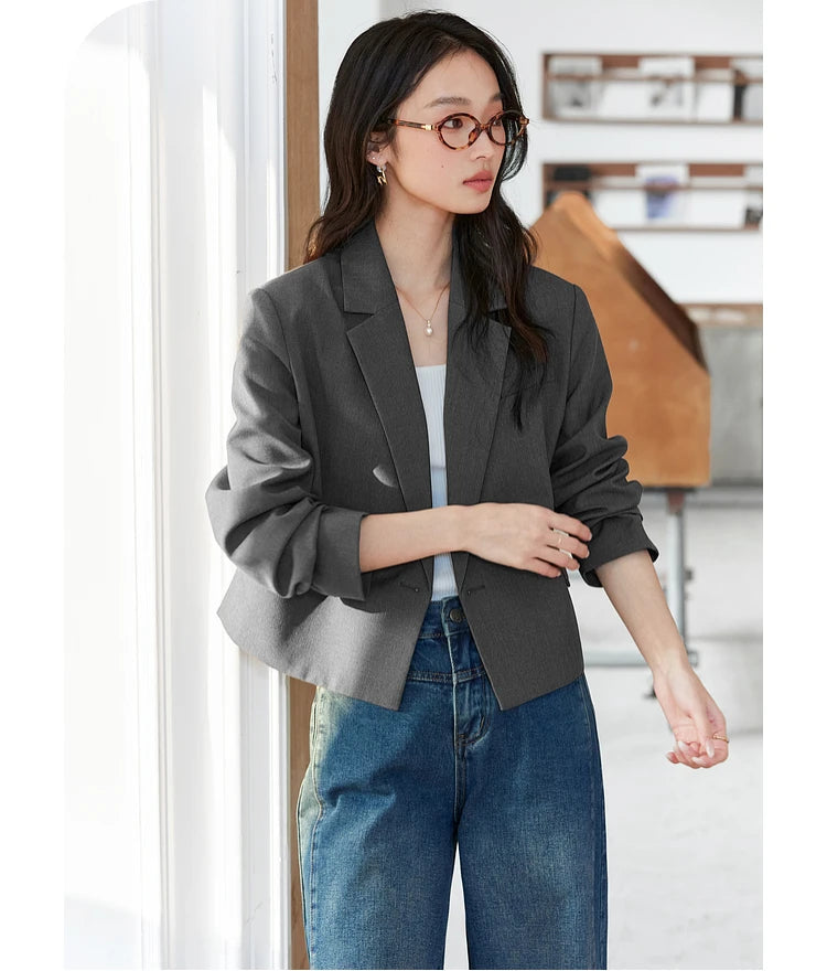 Detail shot of woman adjusting lifted cuff while wearing Davy Grey double-breasted blazer. From Borcelleclothes.