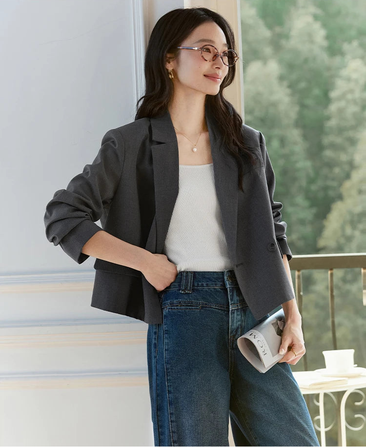 Model wearing Davy Grey double-breasted blazer, hand resting on waist, notch lapels visible. From Borcelleclothes.