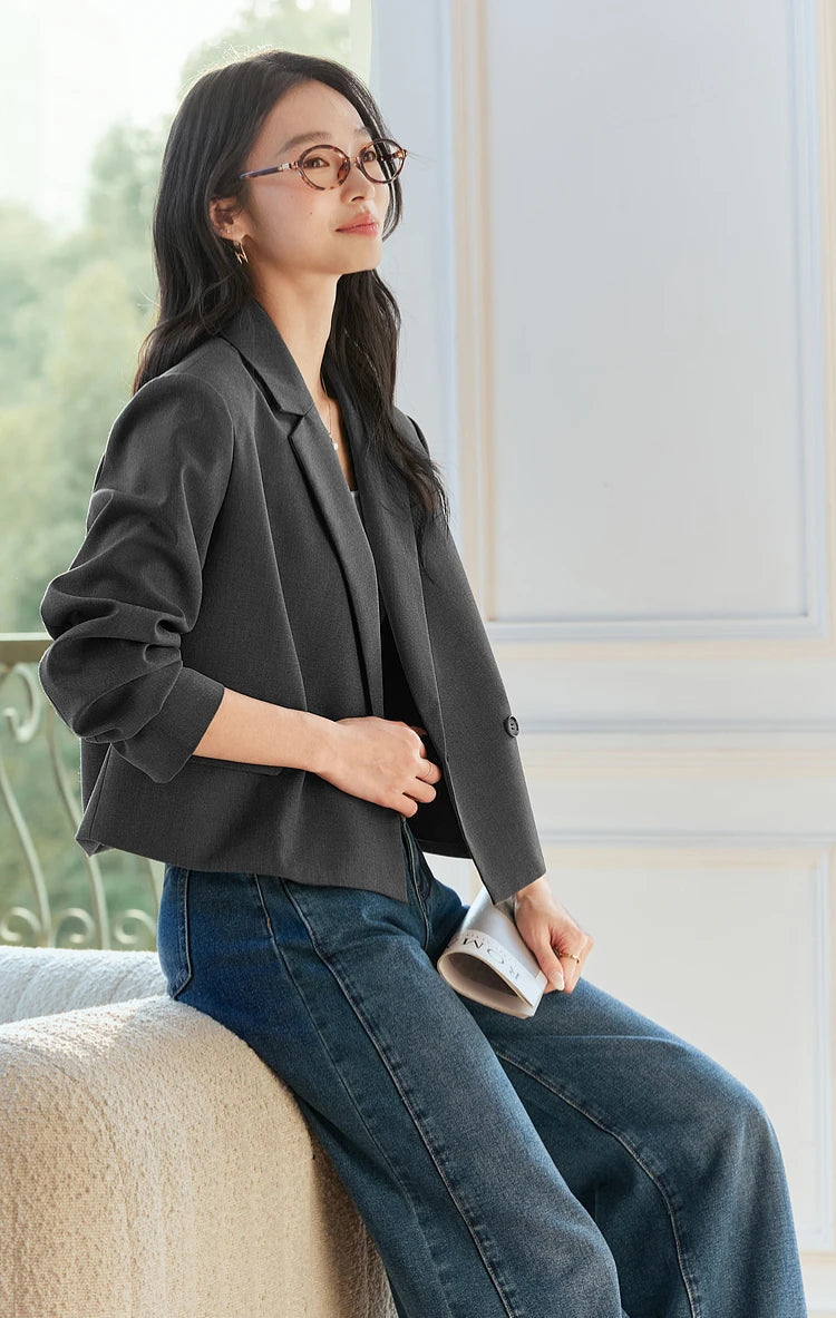 The model is sitting on the backrest of a sofa while wearing the Davy Grey double-breasted blazer. From Borcelleclothes.