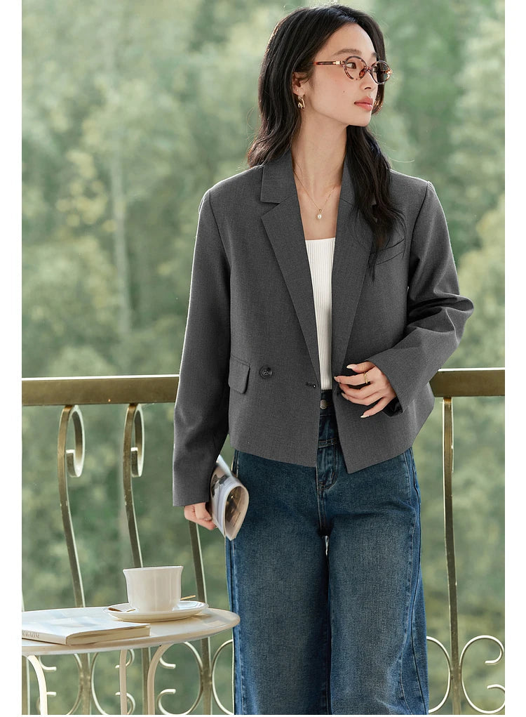 Close view of Davy Grey double-breasted blazer, model touching front side to show structure. From Borcelleclothes.