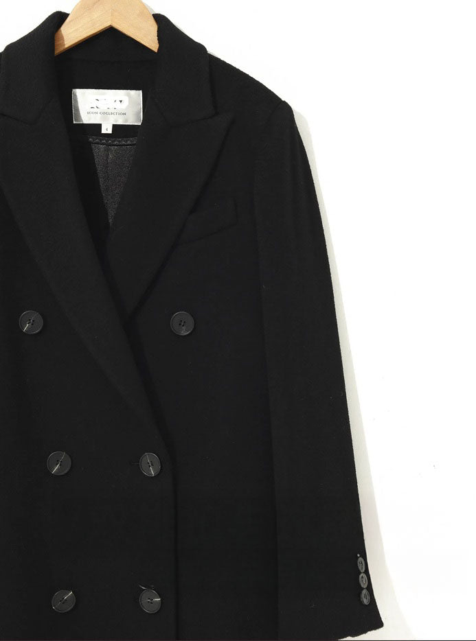 Detail of the upper section of the Onyx double-breasted cashmere wool coat with peaked lapels. From Borcelleclothes.