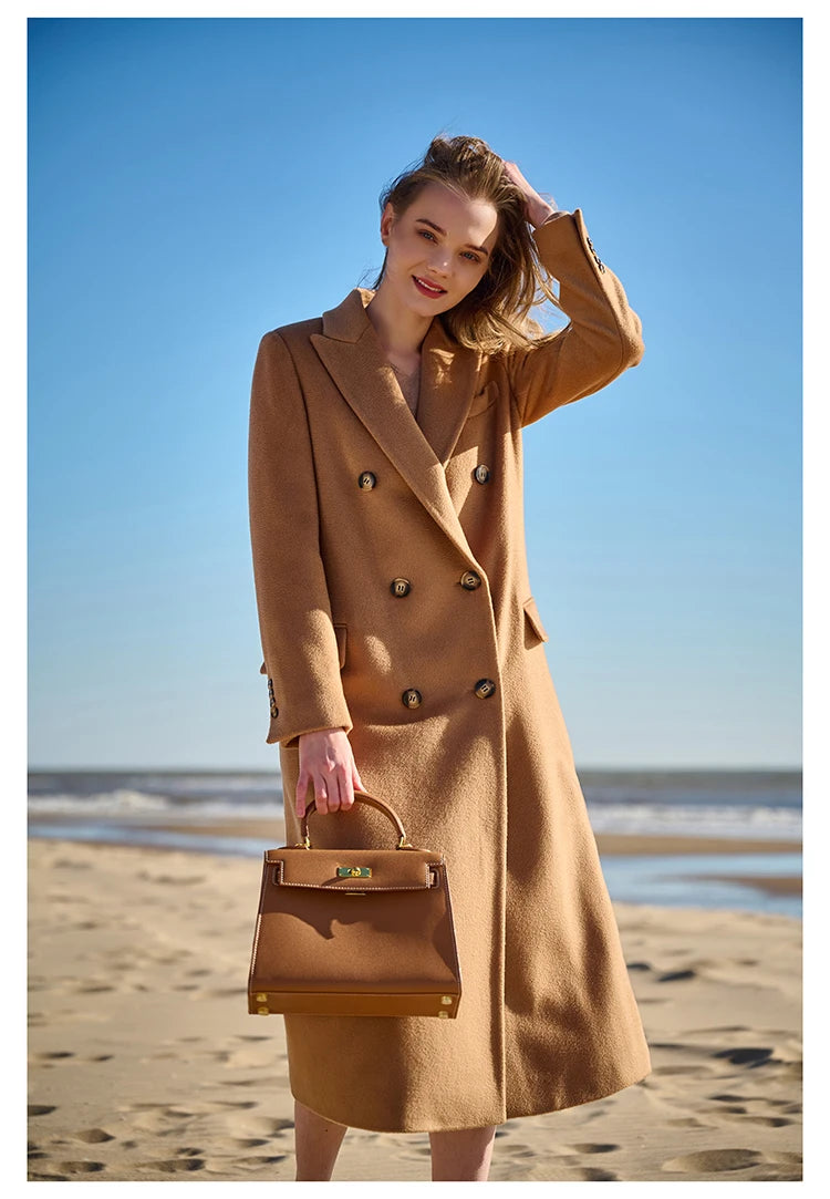 Model in a Potters Clay cashmere wool coat, softly touching her hair. From Borcelleclothes.