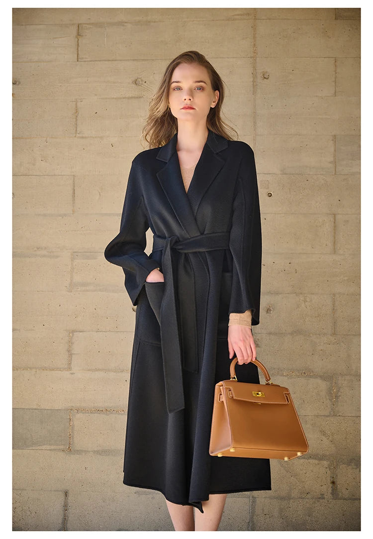 Model wearing a Baltic Sea double-sided cashmere wrap coat, hand in pocket. From Borcelleclothes.