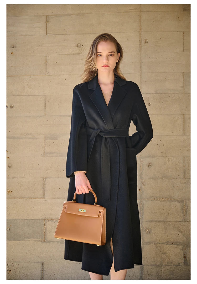 Model wearing a Baltic Sea double-sided cashmere wrap coat, holding a bag. From Borcelleclothes.