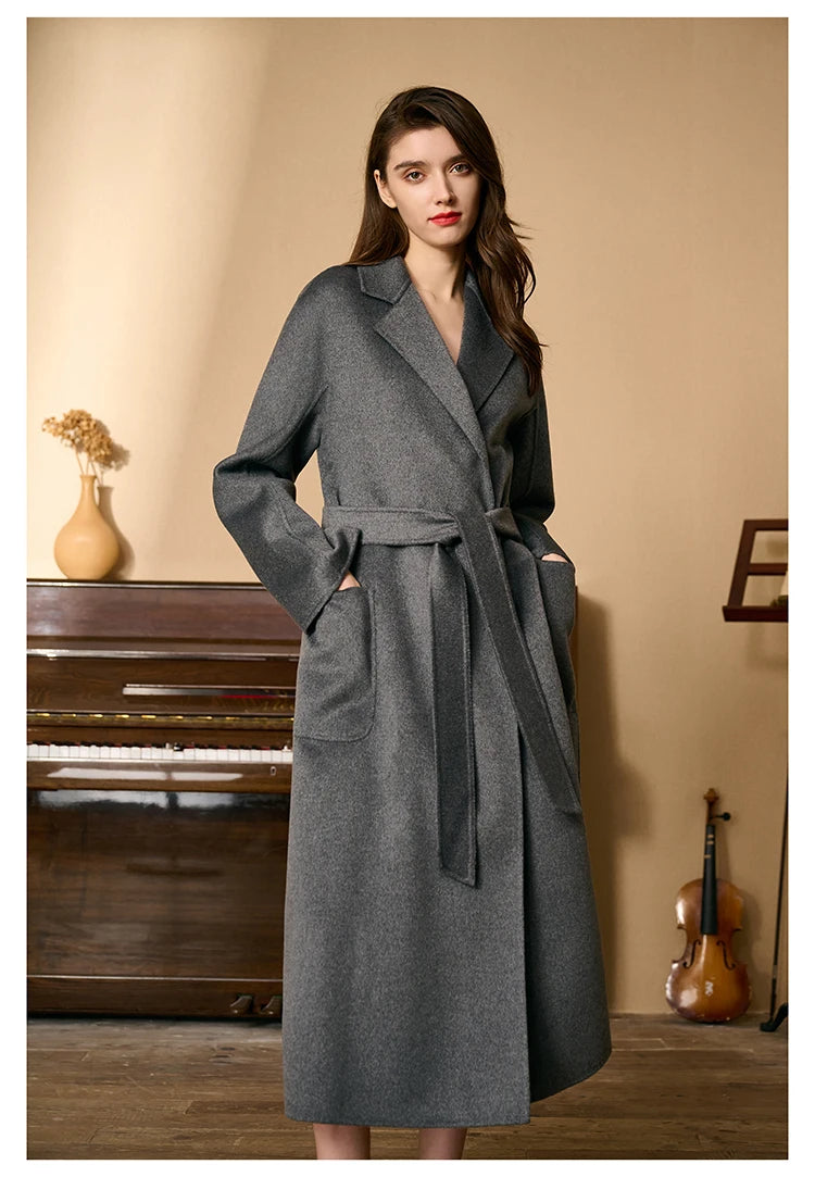 Model wearing a carbon grey double-sided cashmere wrap coat, hands in pockets. From Borcelleclothes.