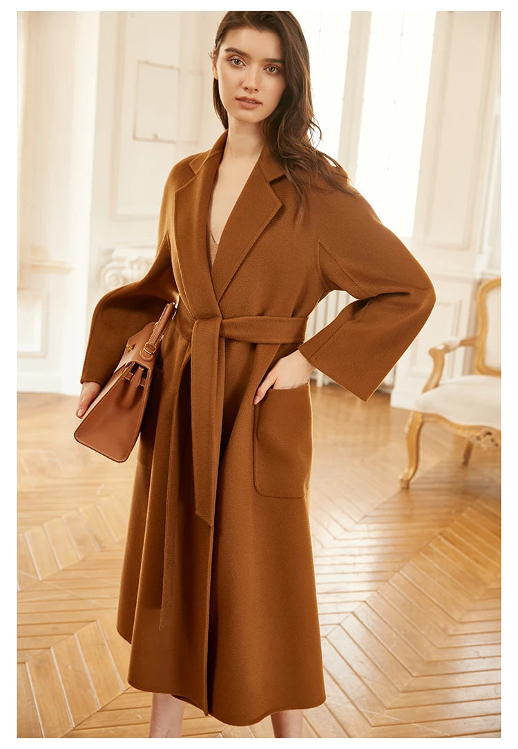 Model wearing a sienna double-sided cashmere wrap coat, holding a bag with one hand in pocket. From Borcelleclothes.