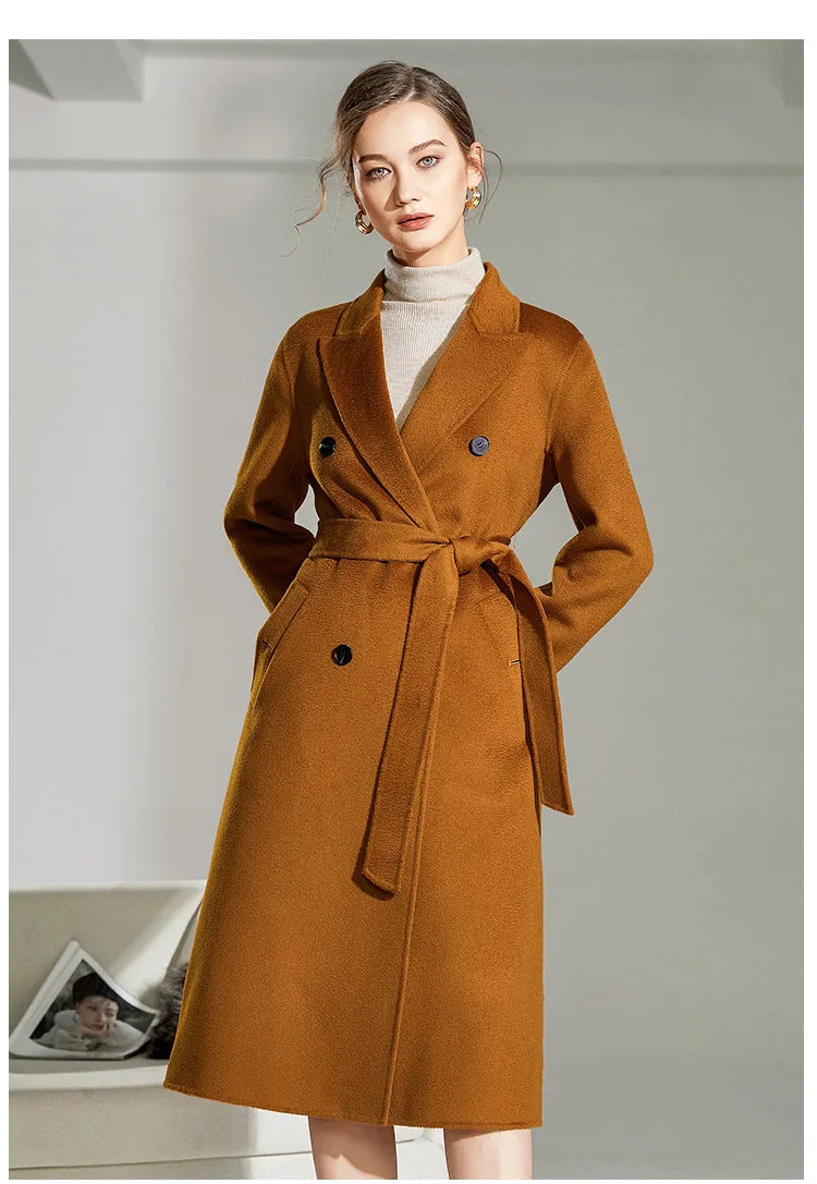 Model in Women's Double-Sided Wool-Cashmere Coat in Bourbon with hands behind back.  From Borcelleclothes.