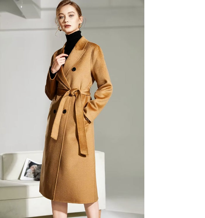 Model wearing the Women's Double-Sided Wool-Cashmere Coat in Brown Sugar, gently touching the peaked lapels to highlight their structure and craftsmanship. From Borcelleclothes.