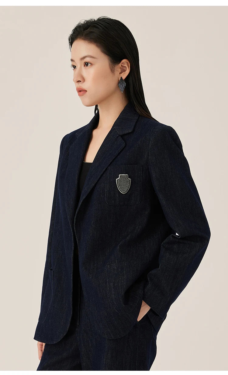 Ebony Clay denim blazer styled with model’s hand in pants pocket, showing patch pocket and relaxed tailoring – From Borcelleclothes.