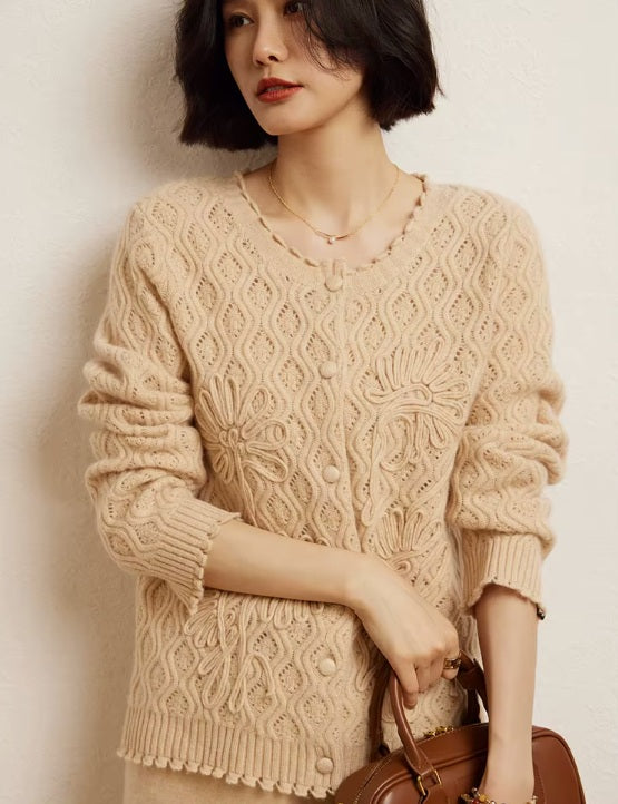 A model wearing the women's Embossed Lace Cashmere Cardigan in Brandy, holding a stylish bag, showcasing the cardigan's refined craftsmanship and modern elegance, Borcelleclothes.