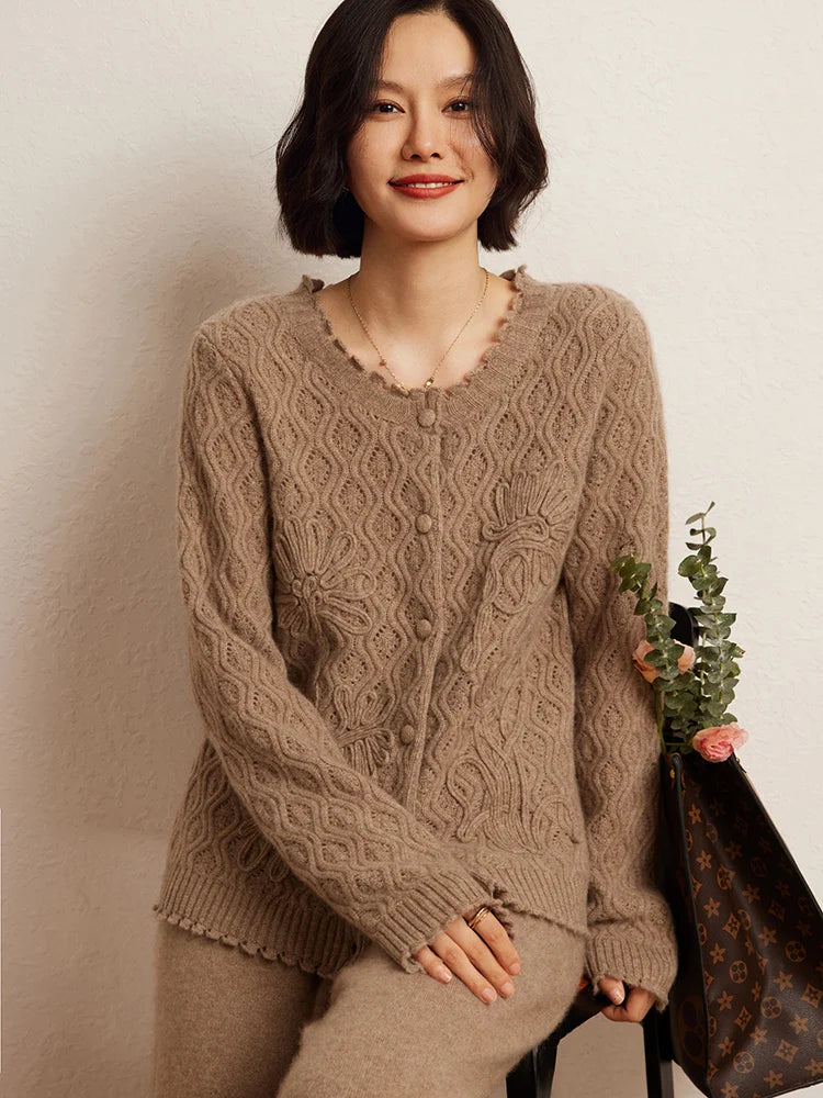 A model perched on the edge of a chair, wearing the women's Embossed Lace Cashmere Cardigan in Light Taupe, highlighting its airy lace and sophisticated style, Borcelleclothes.