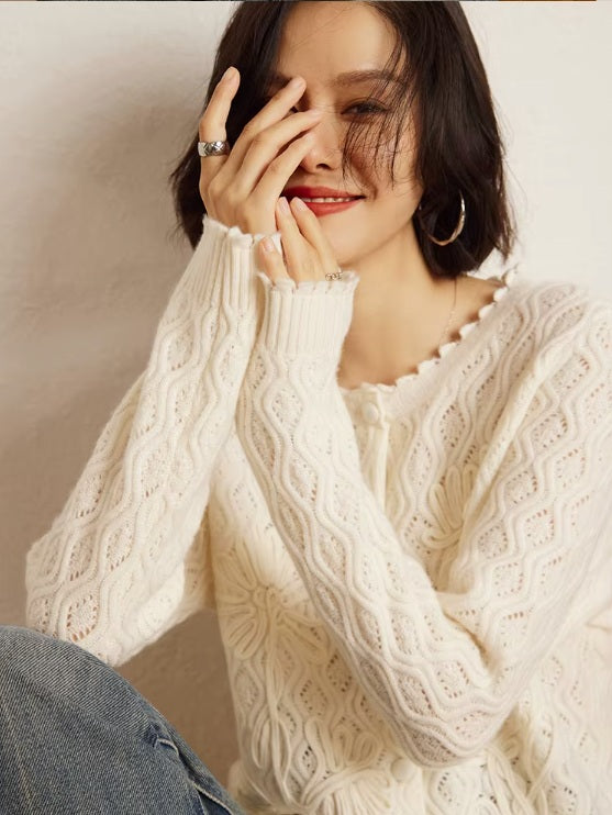 A model wearing the women's Embossed Lace Cashmere Cardigan in Pearl Bush, elegantly watching through her fingers, emphasizing the cardigan's airy and luxurious design, Borcelleclothes.