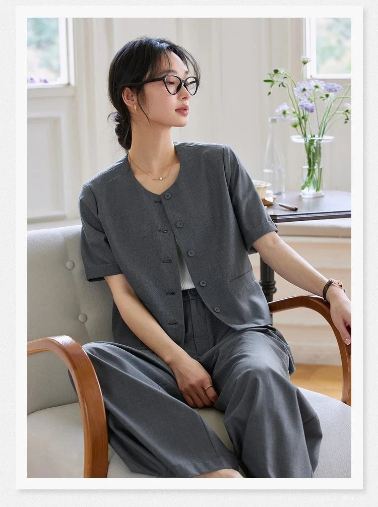 Model sitting in an armchair wearing the Fiord two-piece set. From Borcelleclothes.