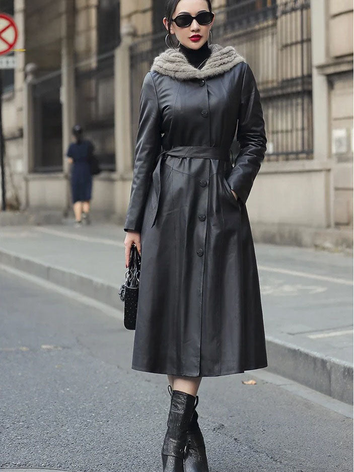 Women's Flared Hooded Coat in Onyx. Model places hand in the hidden side pocket, highlighting the seamless integration of functionality and design. Borcelleclothes.